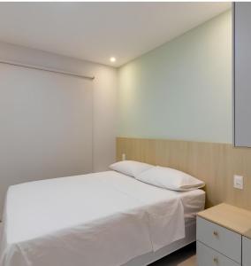 una camera da letto con un letto bianco e una finestra di Lazer - Flat Condomínio Muro Alto Clube a Porto De Galinhas Altre 15 foto