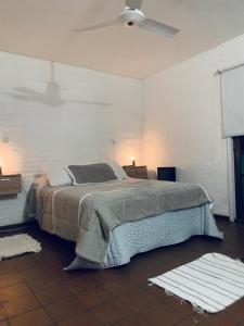 a bedroom with a bed in a white room at Las Moras casa de campo en Lobos in Lobos