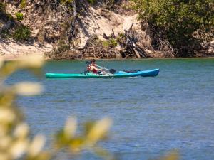 a person in a kayak on a body of water at Kingy Beach Getaway with Balcony - Central Kingscliff in Kingscliff +6 photos