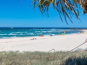 a beach with people laying on the sand and the ocean at Kingy Beach Getaway with Balcony - Central Kingscliff in Kingscliff