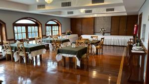 a dining room with tables and chairs in a room at Duplex Luxo Quatre Saisons MBFlats Campos do Jordão 1 in Campos do Jordão