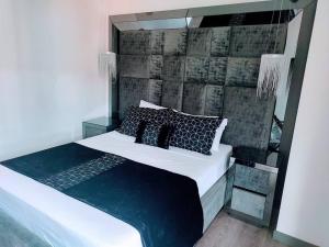 El PobladoClass suites nirvana的一间卧室配有一张带黑色枕头的大床