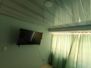 a flat screen tv hanging on a wall next to a window at ECOMOMENTOS in Duitama
