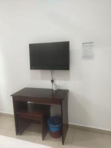 a desk with a flat screen tv on a wall at S&P Hotel in Tampin +7 photos