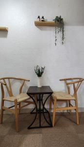 dos sillas y una mesa con un jarrón de flores en la pared en 도토리 창꼬, en Seúl