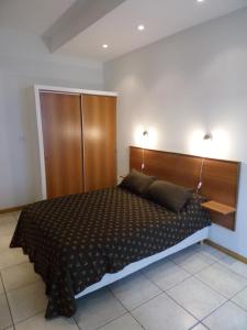 1 dormitorio con 1 cama grande y cabecero de madera en Apartamentos Güemes - Monoambientes en Bahía Blanca