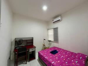 a bedroom with a bed and a desk and a computer at Etosh Homestay 3 in Batu Pahat