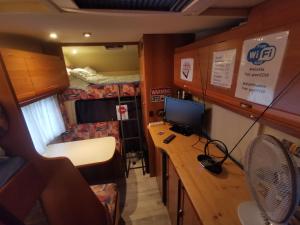 a small room with a desk with a computer on it at Miklós FKK Naturist in Szigetszentmiklós +28 photos