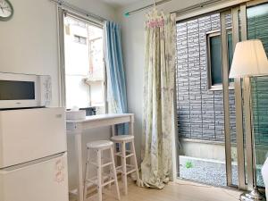a kitchen with a refrigerator and a table and a window at JR t akadababa subway 5 mins walk! Newly building 新築! 高田馬場駅 徒歩圏内大人気! Shinjuku新宿圈!高速无限制Wi-FI BC in Tokyo