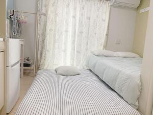 a small bedroom with two beds and a window at JR t akadababa subway 5 mins walk! Newly building 新築! 高田馬場駅 徒歩圏内大人気! Shinjuku新宿圈!高速无限制Wi-FI BC in Tokyo