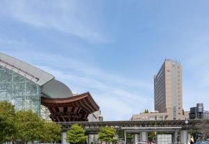 a building with a tall building in the background at Hotel Kanazawa in Kanazawa