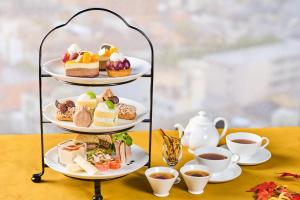 a three tiered tray of desserts and cups of tea at Hotel Kanazawa in Kanazawa