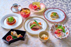 a table with plates of food and bowls of food at Hotel Kanazawa in Kanazawa