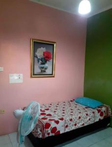 a bedroom with a bed and a fan and a picture at K77 Backpackers - Jungle Tours in Medan