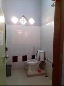 a bathroom with a toilet with a window at K77 Backpackers - Jungle Tours in Medan