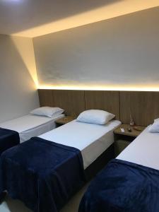 a hotel room with two beds and two tables at Pousada Royal in Mossoró +19 photos