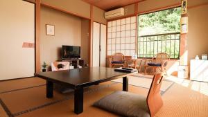 a living room with a table and chairs at くつろぎと料理の御宿花さと -Hanasato- in Minamiizu
