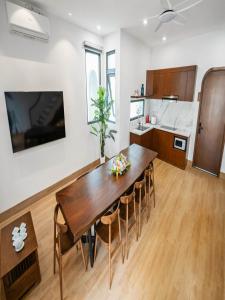 a kitchen and dining room with a wooden table and chairs at Chuỗi Villa 3 Phòng ngủ Sonasea Vân Đồn - Đầy đủ tiện nghi - sân vườn BBQ - Sát bãi biển in Cái Rồng