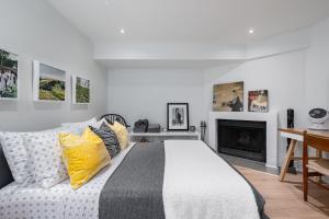 a bedroom with a bed with yellow pillows and a fireplace at Modern Design Studio in Toronto