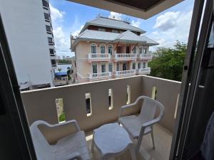 a balcony with two chairs and a building at Bella Bella Riverview in Bangkok +49 photos