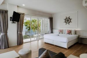 a bedroom with a white bed and a large window at Combo Beach Hotel Samui in Chaweng +196 photos