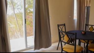 a dining room with a table and chairs and a window at Cielito lindo in Puerto Ángel