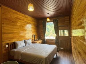 ein Schlafzimmer mit einem Bett in einem Holzzimmer in der Unterkunft Chiba Ecolodge Mù Cang Chải in Mù Cang Chải + 24 Fotos