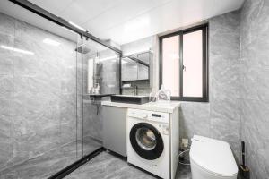 a bathroom with a washing machine and a toilet at 上海柠檬汁民宿 Shanghai lemon juic B&B-Shanghai Lemon Deluxe Room 外滩南京西路步行街 in Shanghai