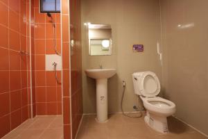 a bathroom with a toilet and a sink at โรงแรมนั่งเล่น in Chon Buri