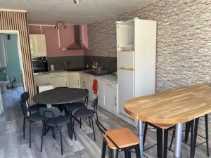 a kitchen with two tables and chairs and a table and a counter at gite du Breuchin 2 in La Longine
