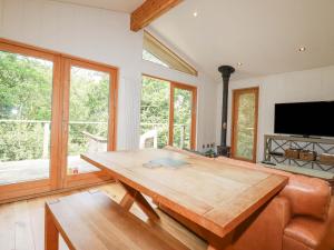 a living room with a wooden table and a couch at 4 Stonerush Valley in Looe
