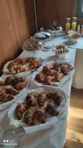 a table with several trays of pastries and other foods at Vicolungo Glamour Lodge & SPA - Free SPA Hot Tub e Sauna in Vicolungo