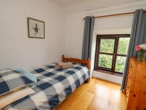 a bedroom with a bed and a window at Fisherman's Cottage in Llandysul