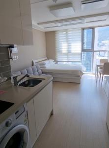 a kitchen and living room with a bed in a room at Busan Station KTX House in Busan