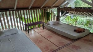 a room with two beds and a table and a chair at hijau in Tjakranegara