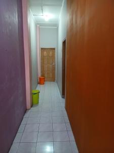 an empty hallway with a door and a tile floor at K77 Backpackers - Jungle Tours in Medan +1 photo