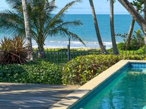 una piscina con el océano al fondo en Frangipani Place - Absolute Beachfront, en South Mission Beach