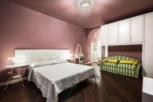 a purple bedroom with a bed and a green chair at Residenza Cavour in Acireale