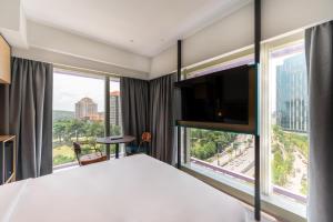 Ein Bett oder Betten in einem Zimmer der Unterkunft Moxy Putrajaya