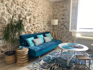 a living room with a blue couch and a table at Appartement La Tourraque côté mer in Antibes