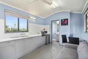 マウント・アイザにあるDiscovery Parks - Argyllaの白いキャビネットとシンクとテーブルのあるキッチン