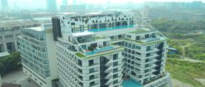 a tall white building in a city at Lime Resort Manila in Manila