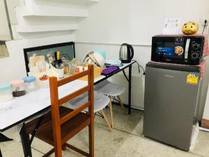 een keuken met een tafel, een magnetron en een koelkast bij Silom Guesthouse in Bangkok +59 foto's