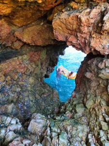 a cave with a person swimming in the water at Captain's View in Dobra Voda