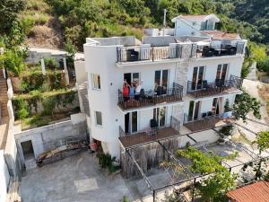 two people standing on the balcony of a white building at Captain's View in Dobra Voda