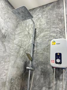 a shower in a bathroom with a light on the wall at JK Studio, Koh Yao Noi in Ko Yao Noi