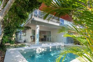 una piscina frente a una casa en Malibu Beach House, en Kingscliff