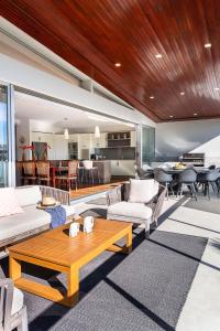 Una sala de estar con sofás y una mesa. en Malibu Beach House, en Kingscliff