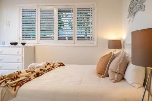 Un dormitorio con una gran cama blanca con ventana. en Malibu Beach House, en Kingscliff 28 fotos más