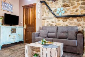 a living room with a couch and a stone wall at La Cuadra in Villar de Corneja